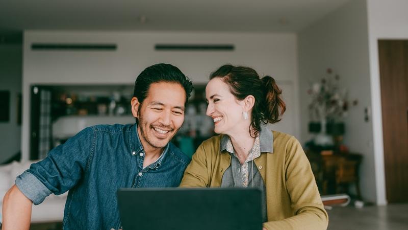 Couple browsing apartment listings together on laptop